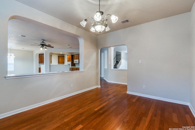 unfurnished room featuring ceiling fan with notable chandelier, hardwood / wood-style floors, and a textured ceiling