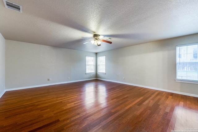 unfurnished room featuring ceiling fan, dark wood-type flooring, and a textured ceiling