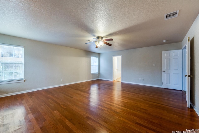 unfurnished room with ceiling fan, a textured ceiling, and dark hardwood / wood-style floors