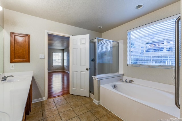 bathroom with separate shower and tub, vanity, tile patterned floors, and a textured ceiling