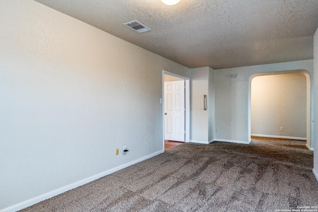 carpeted empty room featuring a textured ceiling