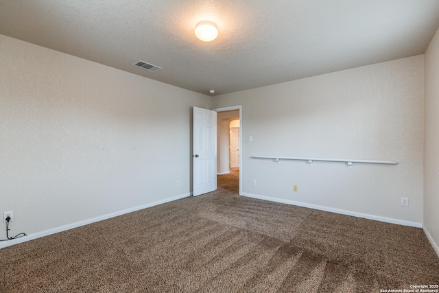 unfurnished room featuring a textured ceiling and carpet flooring