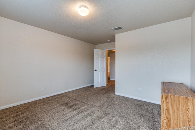 carpeted spare room featuring a textured ceiling