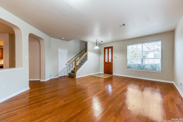 interior space with a textured ceiling and hardwood / wood-style flooring