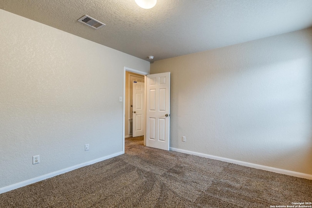 spare room with a textured ceiling and carpet flooring