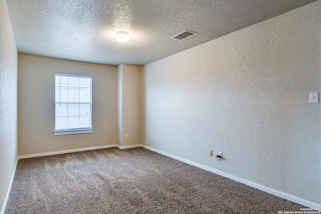 spare room featuring carpet floors and a textured ceiling