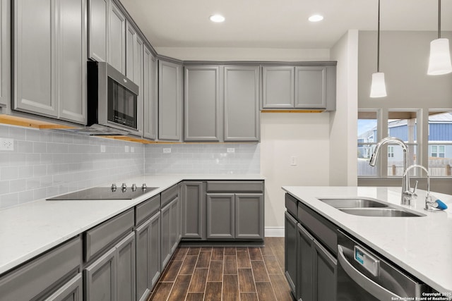 kitchen featuring decorative light fixtures, appliances with stainless steel finishes, sink, and gray cabinets