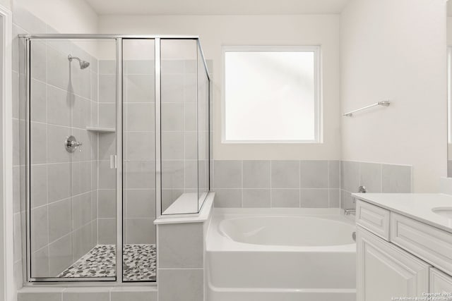 bathroom featuring separate shower and tub and vanity