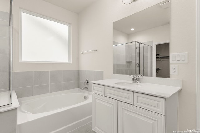 bathroom featuring plus walk in shower and vanity