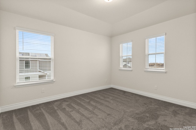 carpeted empty room featuring lofted ceiling