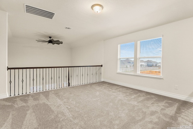 carpeted spare room featuring ceiling fan