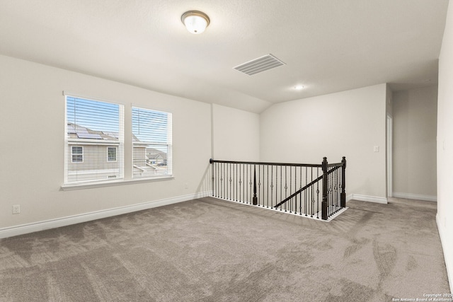 empty room with lofted ceiling and carpet flooring