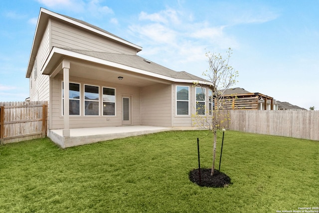 rear view of house with a lawn and a patio