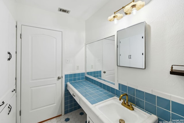 bathroom featuring tile walls and vanity