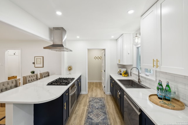 kitchen with white cabinetry, sink, island range hood, and a kitchen bar