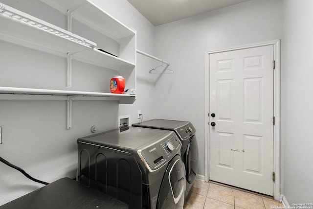 laundry room with laundry area, light tile patterned flooring, washer and clothes dryer, and baseboards