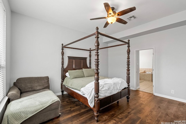 bedroom with dark wood-style floors, ensuite bathroom, visible vents, and baseboards