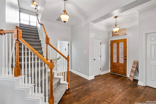 foyer entrance with dark wood-style floors, stairway, and baseboards