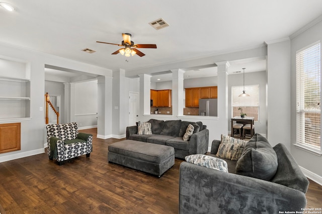 living room with baseboards, dark wood finished floors, visible vents, and ornate columns