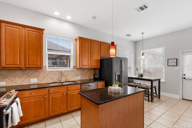 kitchen featuring stainless steel appliances, pendant lighting, visible vents, and a sink