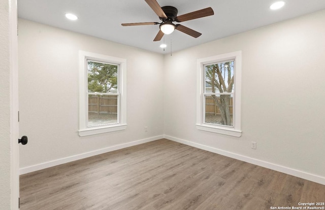 unfurnished room featuring ceiling fan, a wealth of natural light, and light hardwood / wood-style flooring