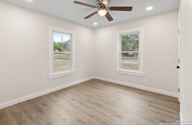 unfurnished room featuring ceiling fan, a wealth of natural light, and light hardwood / wood-style floors