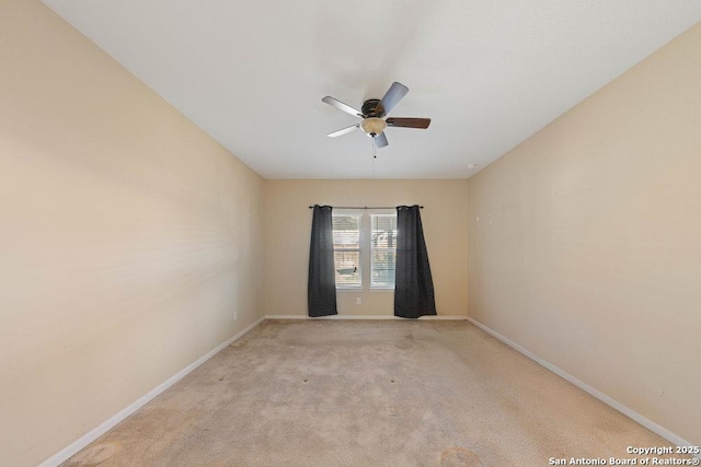 empty room featuring ceiling fan and light colored carpet