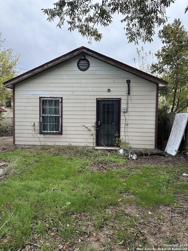 rear view of house featuring a yard