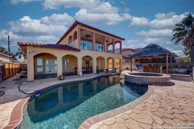 back of property with a swimming pool with hot tub, ceiling fan, a patio area, a gazebo, and a balcony