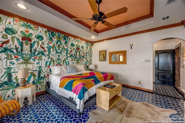 carpeted bedroom featuring baseboards, crown molding, arched walkways, and a tray ceiling