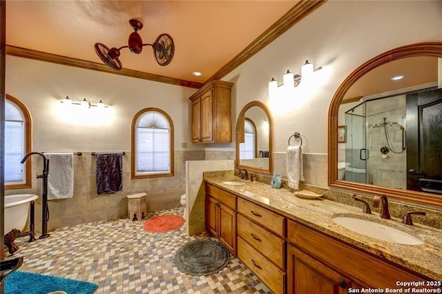 bathroom with ornamental molding, a sink, tile walls, and a shower stall