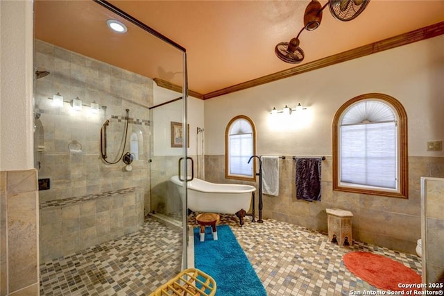 full bath with tile walls, a freestanding bath, ornamental molding, a stall shower, and tile patterned flooring