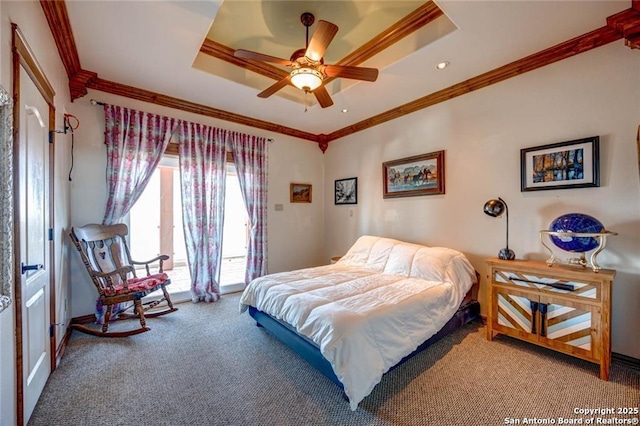 carpeted bedroom with ceiling fan, a tray ceiling, and ornamental molding