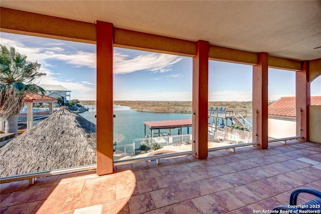 exterior space featuring a healthy amount of sunlight, a water view, and stone finish floor