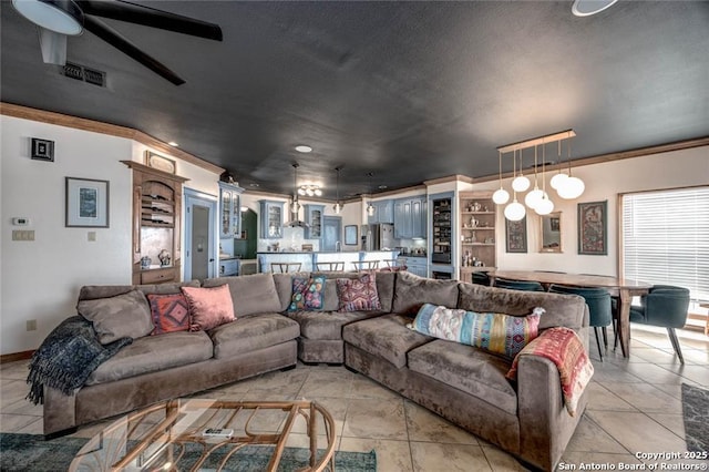 living room with light tile patterned floors, a ceiling fan, visible vents, and crown molding