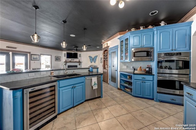 kitchen featuring appliances with stainless steel finishes, blue cabinetry, and sink