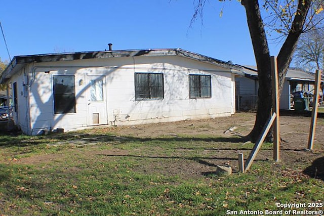 back of house featuring a lawn