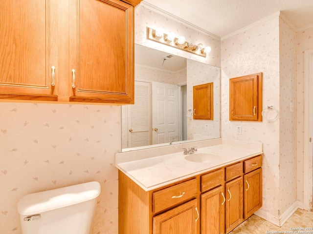 bathroom featuring toilet, vanity, crown molding, and a textured ceiling