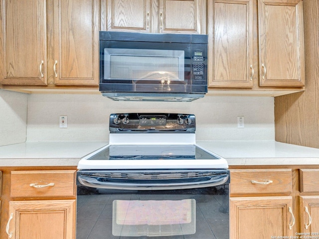 kitchen featuring electric range oven and tile patterned floors