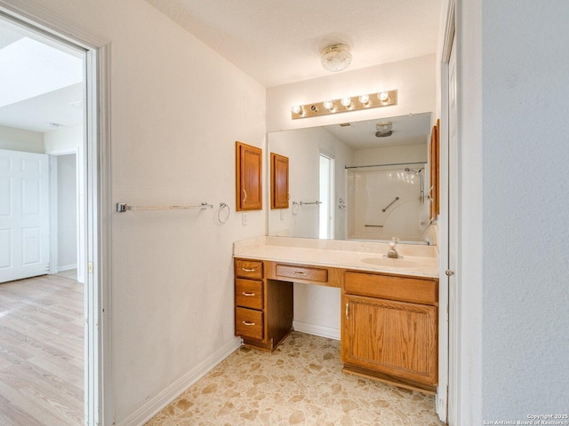 bathroom featuring a shower and vanity