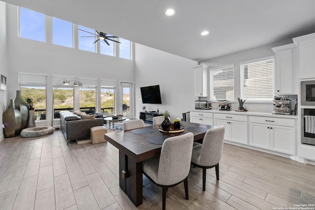 dining room featuring ceiling fan and a high ceiling