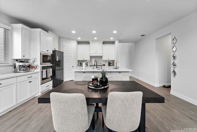 dining space featuring sink and light hardwood / wood-style floors