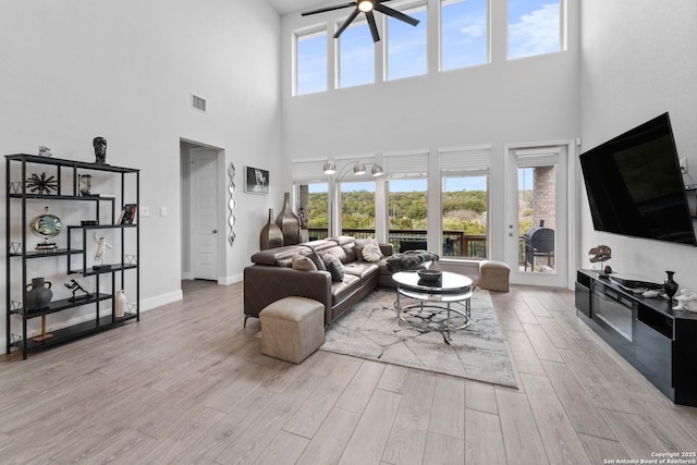 living room with ceiling fan and a high ceiling