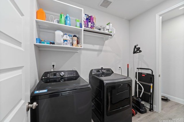 washroom featuring independent washer and dryer and light hardwood / wood-style flooring