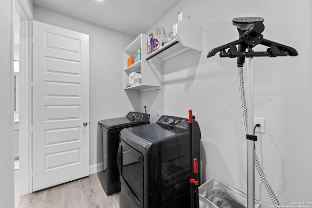 washroom featuring washing machine and dryer and light hardwood / wood-style flooring