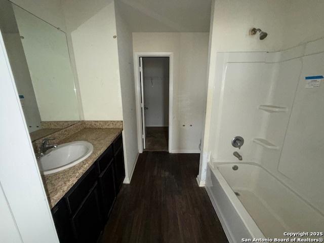 bathroom with vanity, wood-type flooring, and washtub / shower combination