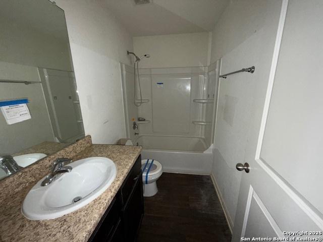 full bathroom with toilet, bathing tub / shower combination, hardwood / wood-style flooring, and vanity