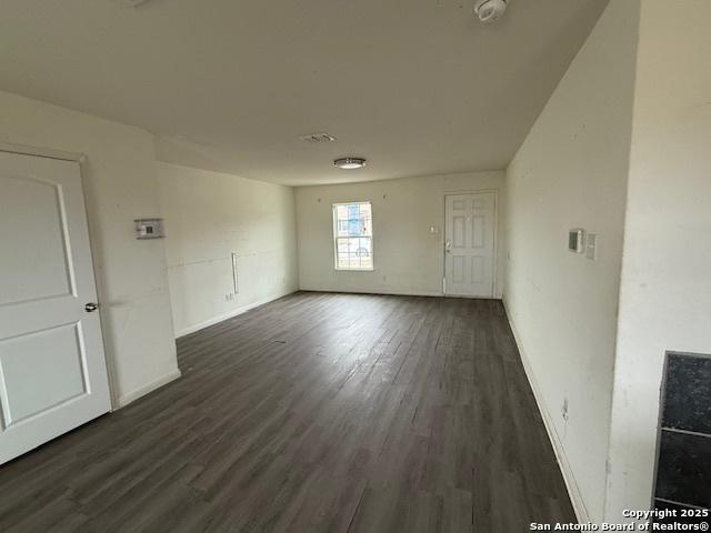 unfurnished room featuring dark wood-type flooring