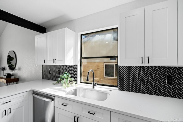 kitchen featuring stainless steel dishwasher, decorative backsplash, sink, and white cabinetry