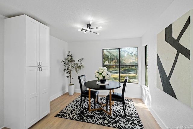 dining room featuring light wood-type flooring and a chandelier